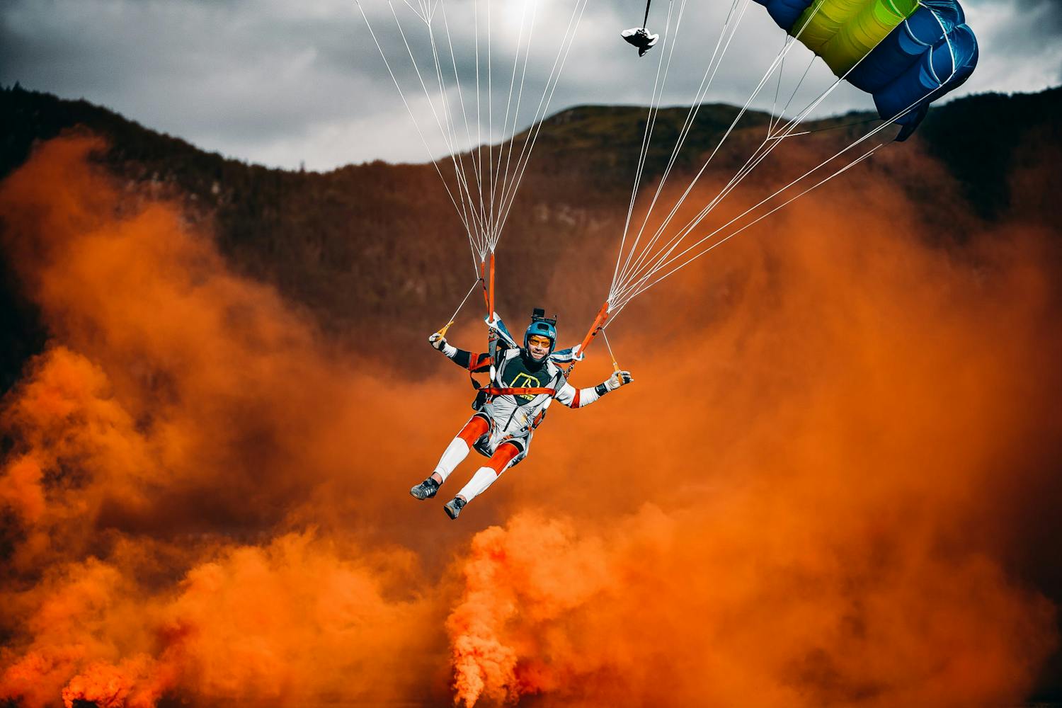 Kaisa Tiivelin kuva laskuvarjohyppääjästä ja savupommeista.